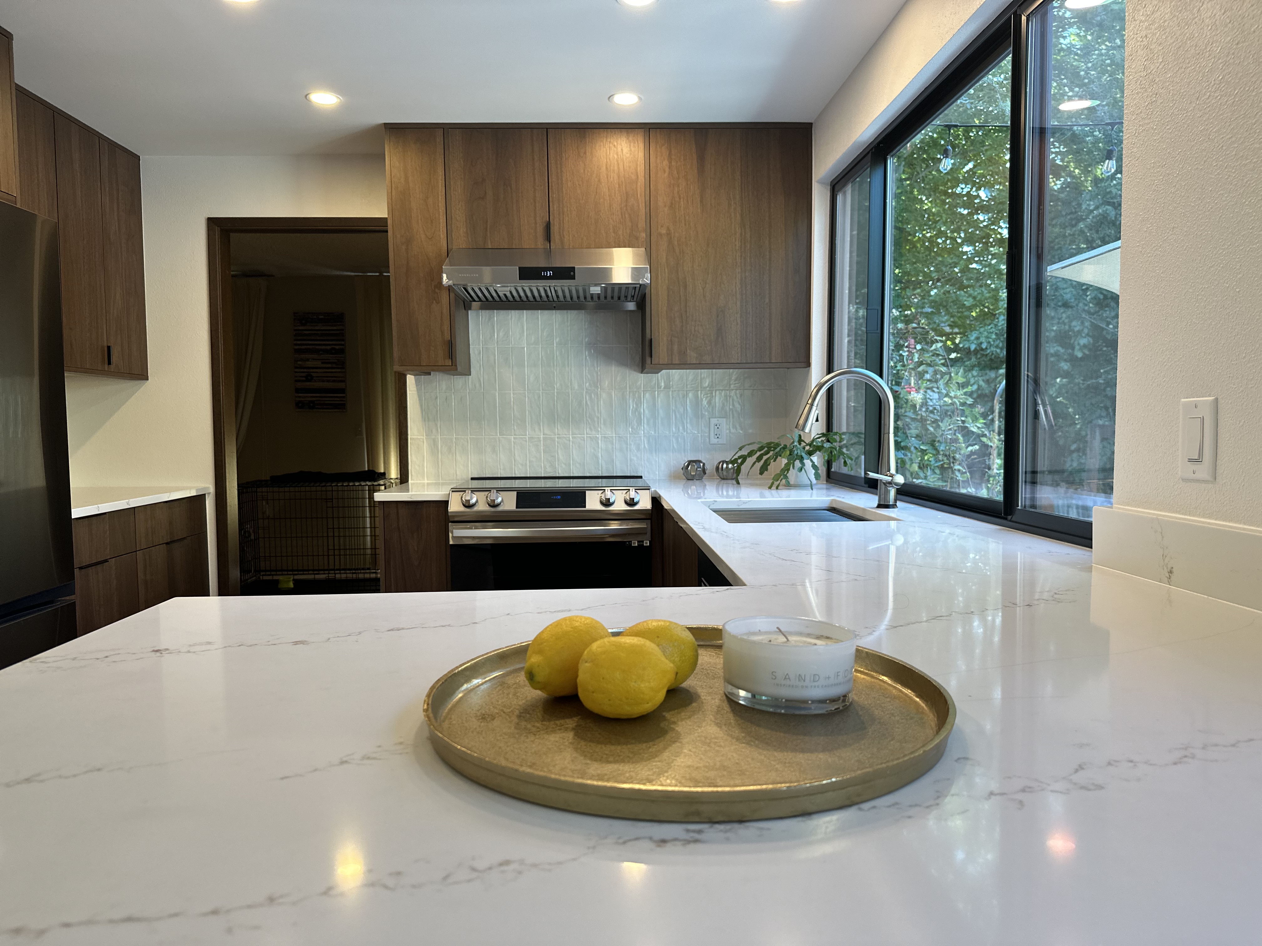 Warm modern veneer kitchen with slab doors and long run of uppers.