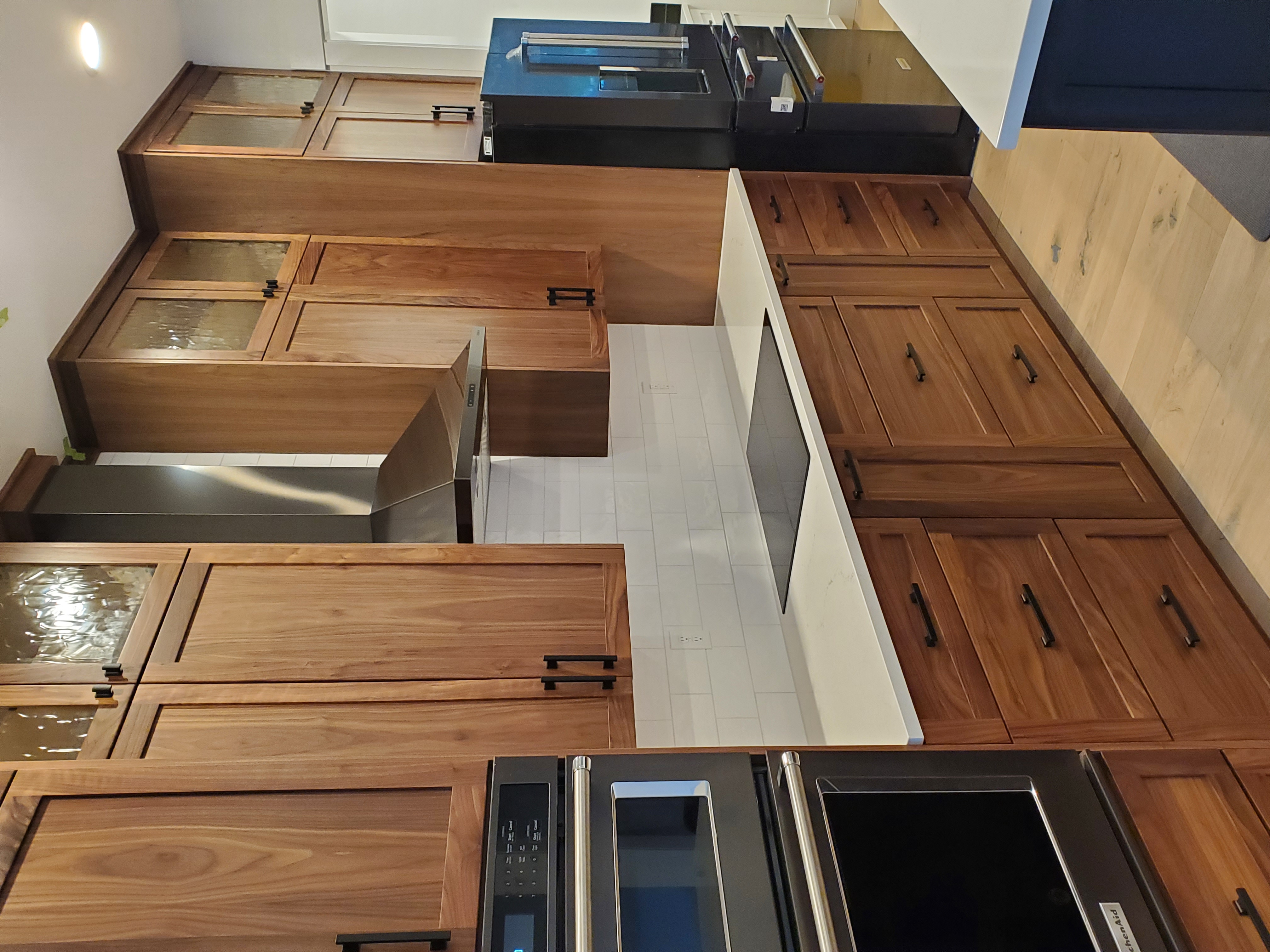 Walnut kitchen with tall uppers, drawers, and integrated hood.
